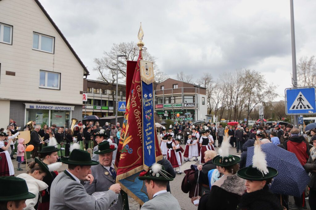 Am Bahnhofsplatz haben sich die Blaskapellen, Besucher, Gäste versammelt, der Trachtenverein führt Tänze auf