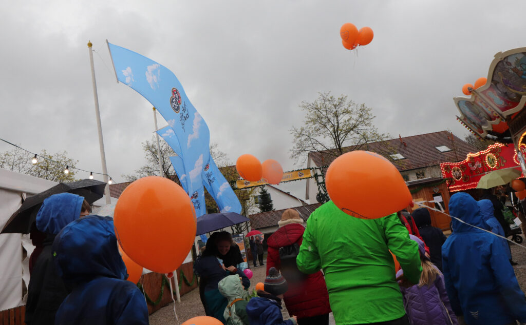 Trotz Regen und grauem Himmel machen sich die kleinen Besucher des Kindertages bereit, ihre Ballons beim Ballonflug-Wettbewerb fliegen zu lassen