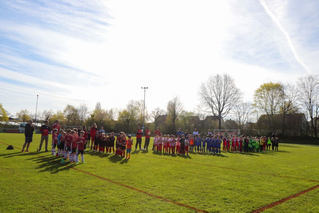 Alle Teams des Fußballturniers 2023 stellen sich auf dem Platz auf, bevor der AUFTAKTCup 2023 offiziell eröffnet wird.