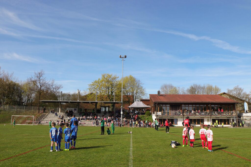 Die ersten Teams des Fußballturniers 2023 machen sich bereit für den Start. Im Hintergrund ist eine große Zahl an Zuschauern zu sehen.