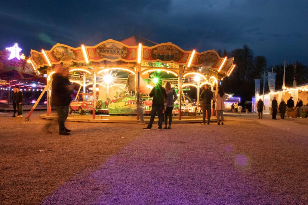Bunt beleuchtetes Kinderkarussell am Abend