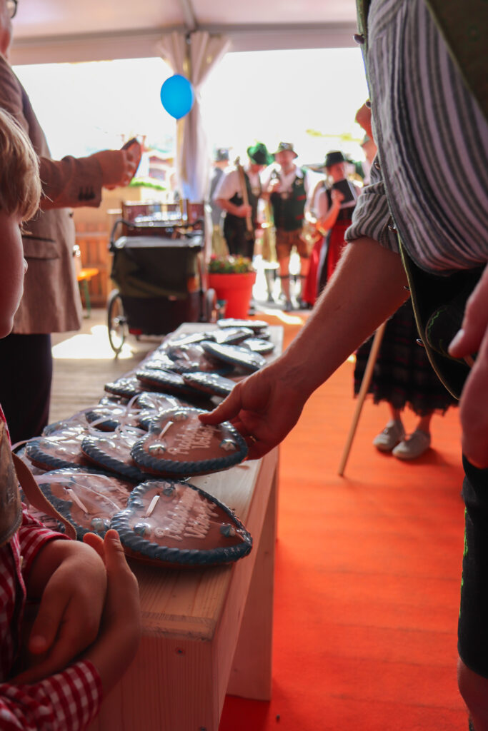 Festzugsteilnehmer:innen erhalten Lebkuchenherzen bei der Ankunft im Festzelt
