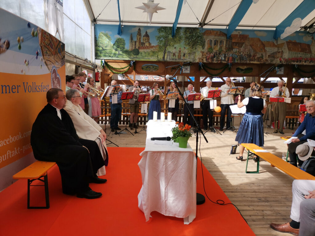 Die Pfarrer genießen den Auftritt vom Posaunenchor beim Gottesdienst im Festzelt