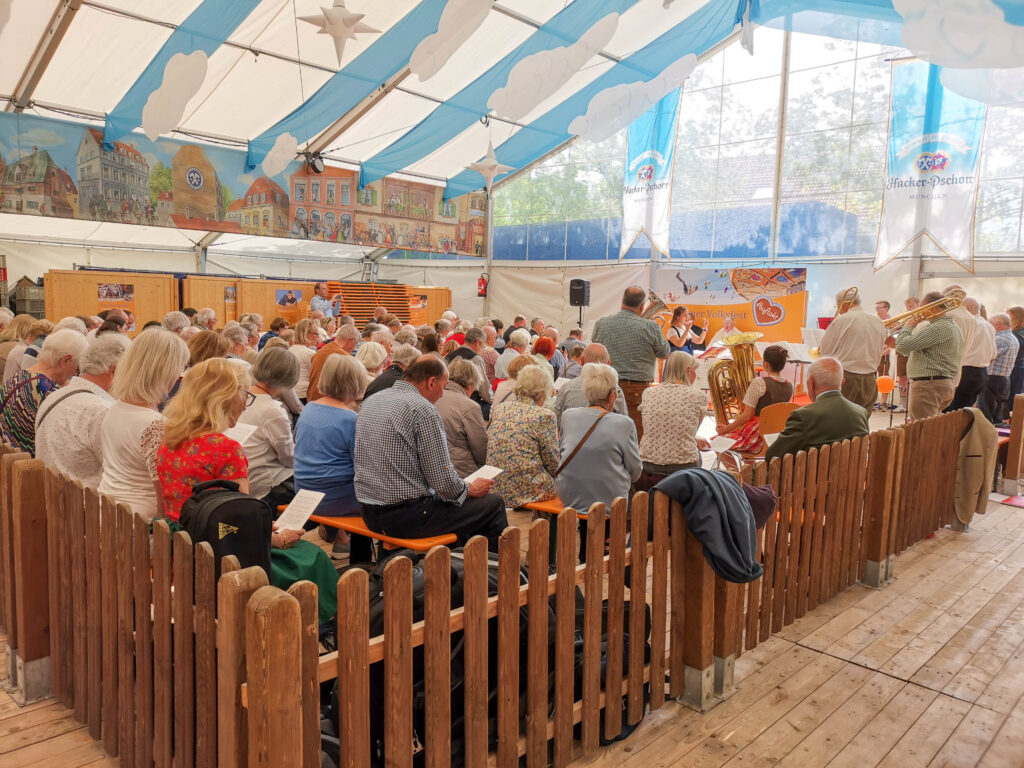 Besucher und Besucherinnen beim Gottesdienst im Festzelt